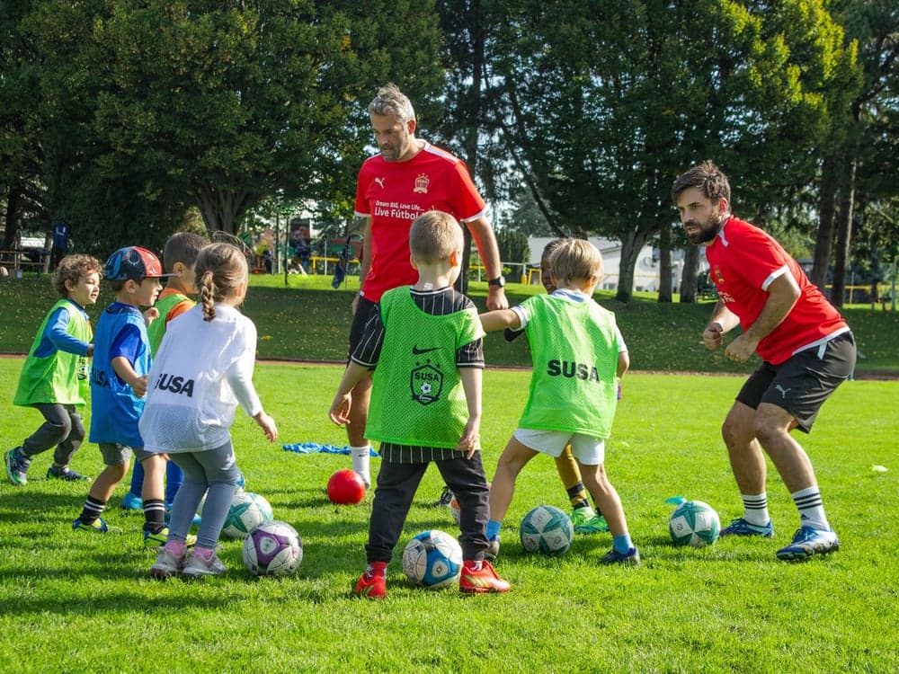 Two SUSA coaches with a group of young players