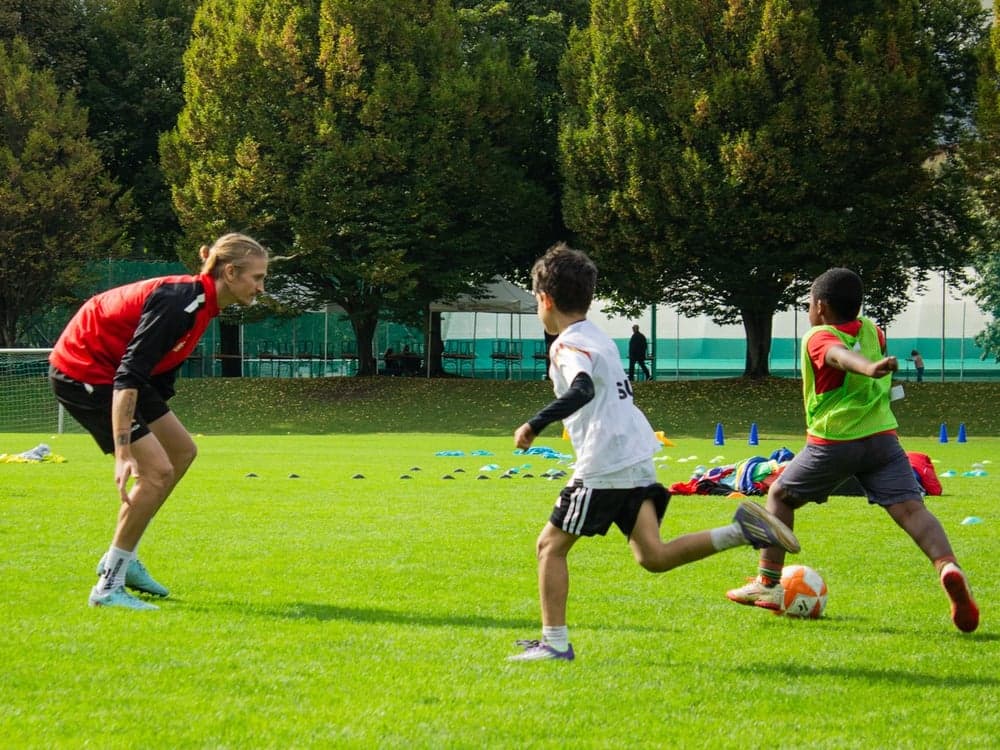 SUSA coach observing two boys playing football