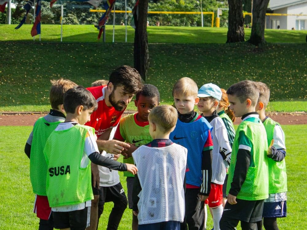 SUSA coach instructing young players in training pinnies